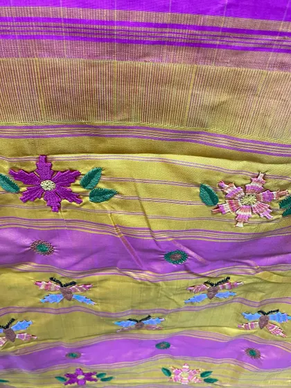 The rich texture of the Kamal Kadai flowers and butterflies against the shimmering silk and gold of the Kanjeevaram border. This is the kind of detail that makes a hand-embroidered saree a true heirloom.