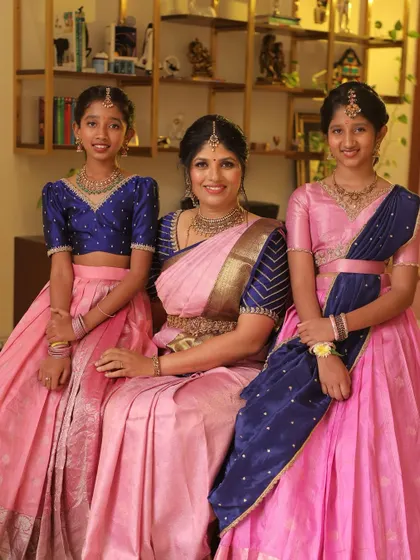 A perfect family portrait. A mother in her beautiful pink and blue saree, flanked by her two daughters in coordinated lehengas.