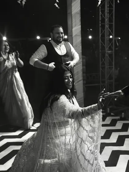A black and white photo of the bride dancing, capturing a moment of joy and interaction on the dance floor.