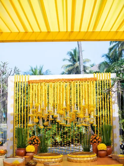 A classic marigold backdrop for a traditional Haldi ceremony. The dense arrangement of yellow flowers creates a rich and auspicious setting for the function.
