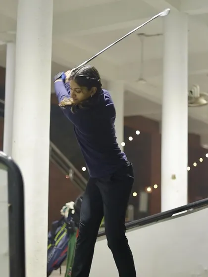 This photo captures the peak of the backswing, showcasing the shoulder turn and wrist hinge that generate power. Our coaches help you master this motion.
