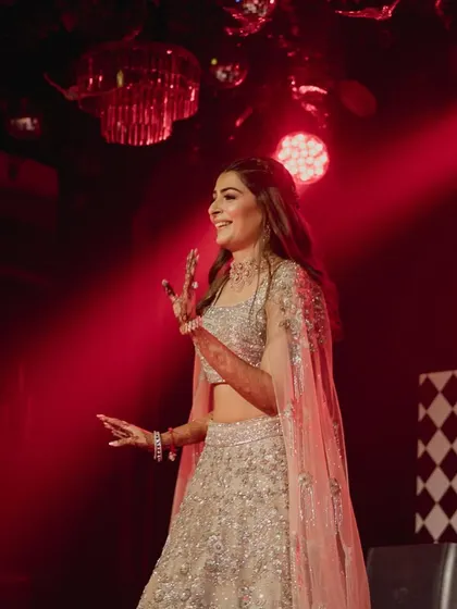 A candid shot of the bride enjoying her sangeet performance, glowing with happiness.