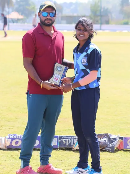 A coach presents an award to a player from the visiting SST Academy team.