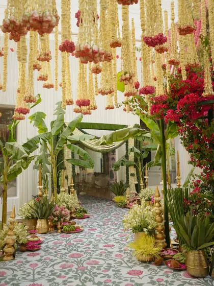 A stunning indoor walkway decorated in a traditional South Indian style with banana plants and hanging floral arrangements.
