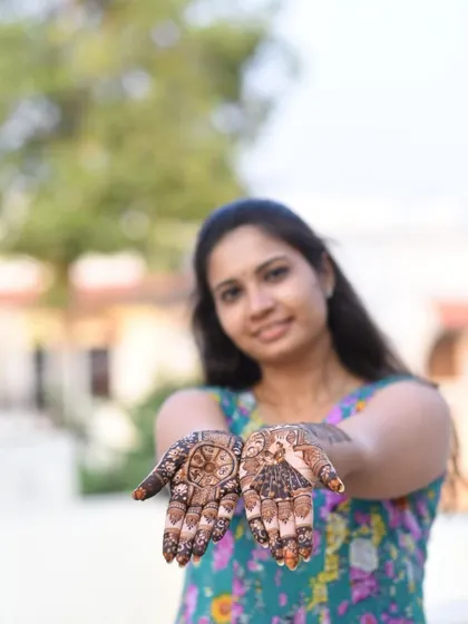 A happy client showing the lovely stain of her custom portrait mehndi.