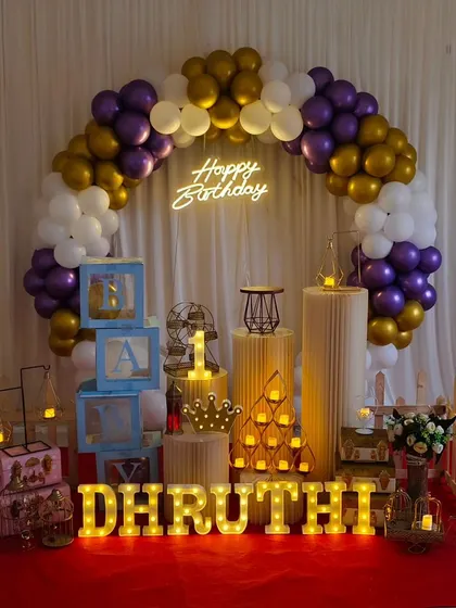 This elegant setup with purple, gold, and white balloons, along with various props and marquee letters, is part of our premium affordable packages.