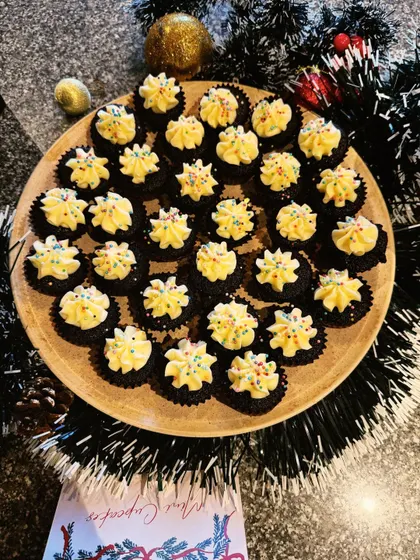 A platter of mini cupcakes with yellow frosting and sprinkles, part of a large Christmas party order for over 200 people. I'm so proud of my team for pulling this off.