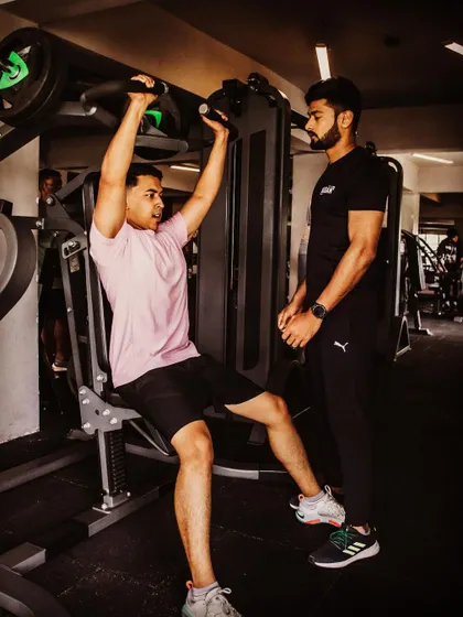 A different angle of a personal training session, focusing on the shoulder press. I provide hands-on coaching to help clients push their limits effectively.
