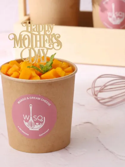 A close-up of our Mango & Cream Cheese dessert tub, topped with a "Happy Mother's Day" pick. This is a simple yet delicious way to treat your mom.