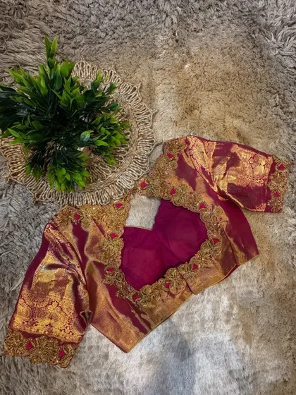 A full view of a custom magenta blouse, showcasing the combination of traditional silk fabric with contemporary embroidery design.