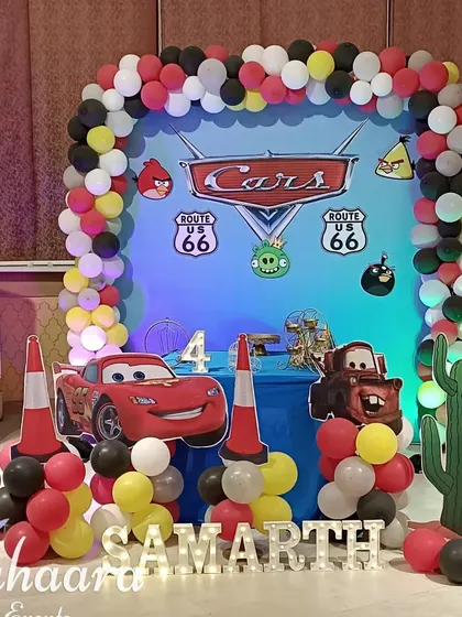 Ready, set, go! A high-energy 'Cars' themed birthday decoration for a 4th birthday. The setup includes a Lightning McQueen cutout, a balloon arch in the theme's colors, and Route 66 signs.