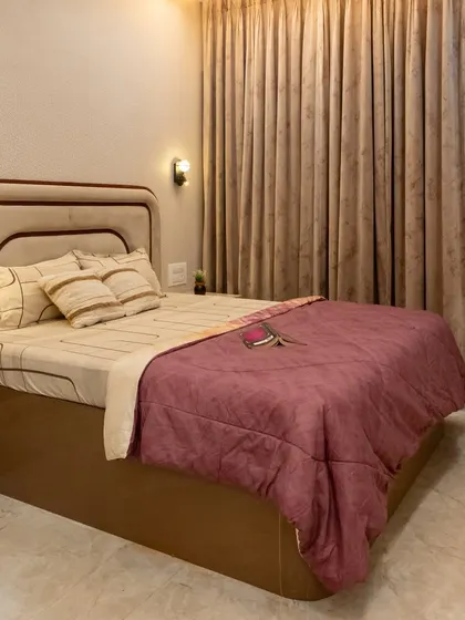 This master bedroom is a serene retreat, featuring a custom-curved headboard, soft lighting, and a hidden projector for movie nights in bed.