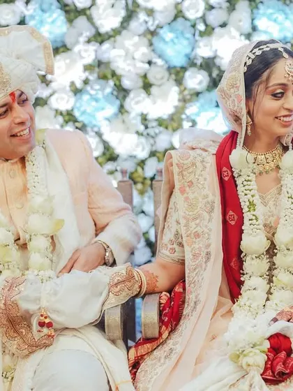 A candid moment of the couple seated during their ceremony, sharing a quiet, happy look.