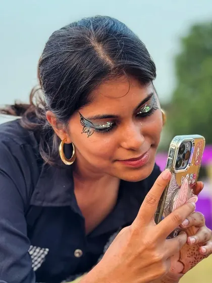 A client taking a selfie of her cool black butterfly wing eyeliner.