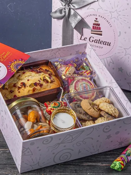 Our Diwali Indulgence Hamper is a step up, featuring a tea cake, dry fruits, gourmet cookies, cracker chocolates, and a handcrafted diya. It's a complete festive package.
