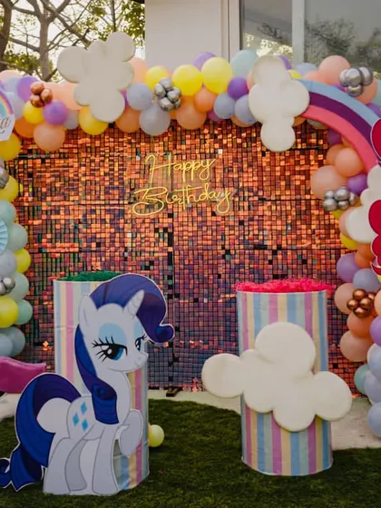 The main photo booth for the My Little Pony theme, with a sparkling rose gold backdrop and cutouts of Pinkie Pie and Rarity.