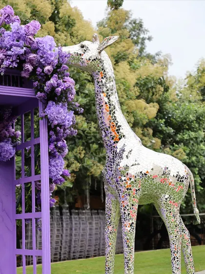 A close-up of the mirrored giraffe next to the purple floral phone booth, a truly unique and artistic combination.