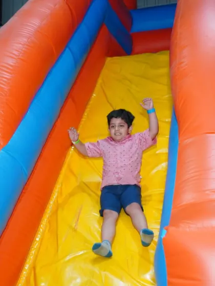 Whee! A young boy enjoys a fast and fun ride down one of our bright and colorful inflatable slides.
