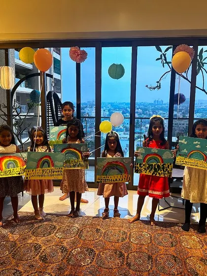 A group of happy kids showing off their rainbow paintings at a private birthday party. Their smiles say it all.