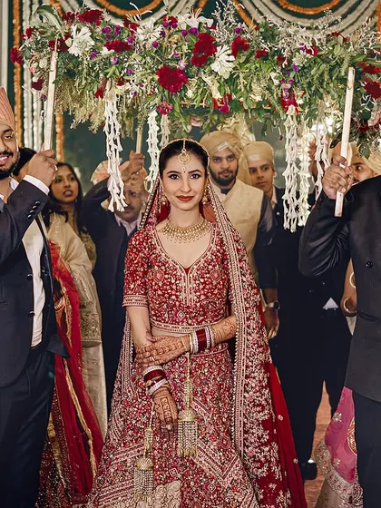The bride makes her way to the mandap under a beautiful 'phoolon ki chaadar' held by her brothers. A classic and emotional moment.