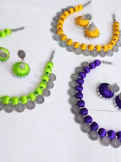 Another view of the custom silk thread necklace sets, showcasing the beautiful oxidized silver charms that complement the colorful threads.