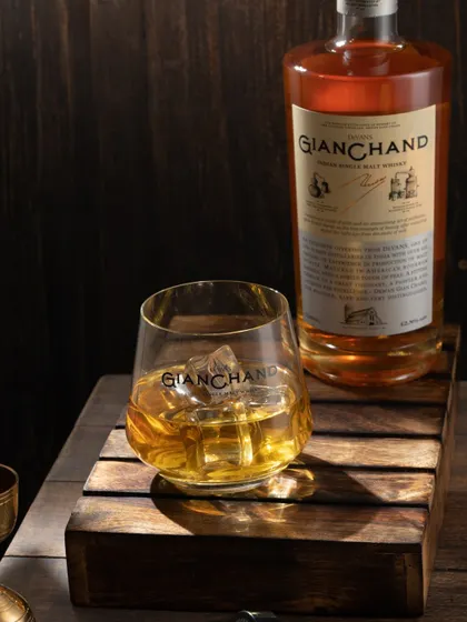 This shot of a single malt whisky uses dramatic, shadowy lighting to create a sense of luxury and timelessness. The wooden props add to the aged, premium feel.