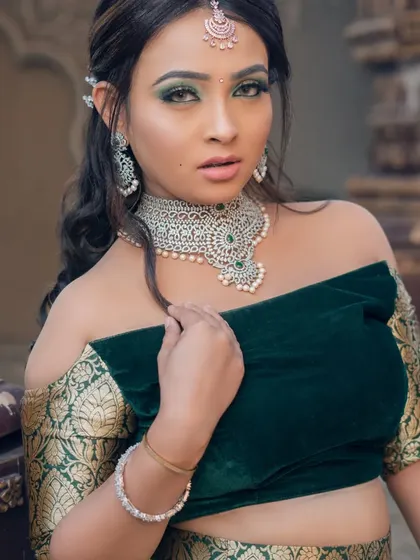 A modern green lehenga with an off-shoulder velvet blouse, paired with a silver-finish diamond and pearl choker. A chic and contemporary choice for a Mehendi or Sangeet.