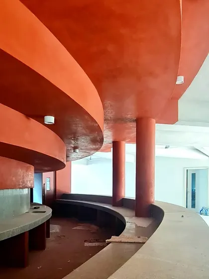 The curved forms of the TAPMI Centre's interior spaces taking shape with the application of red oxide plaster.