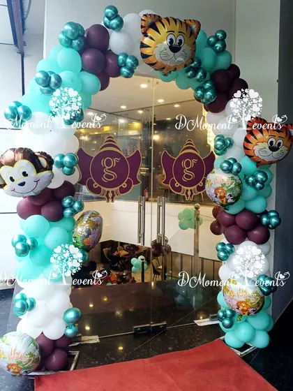 A fun jungle-themed balloon arch at the entrance, decorated with monkey and tiger foil balloons to greet the party guests.