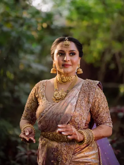 The bride, a vision of elegance in her traditional South Indian saree and gold temple jewellery.