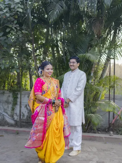 A full-length portrait of the couple in their beautiful wedding attire, capturing the elegance of a traditional Maharashtrian look.
