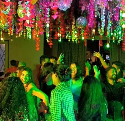The guests are having a blast, dancing under the colorful floral ceiling.