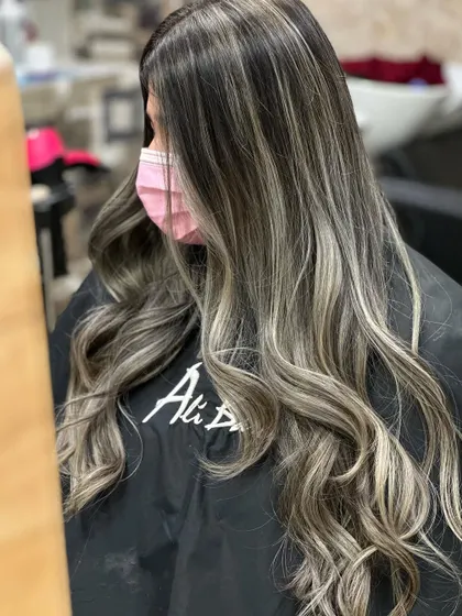 A side view of the long ash blonde hair, showing the seamless blend from roots to ends.