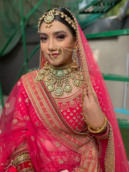 This bride is a vision in pink. She paired her bright pink lehenga with a stunning mint green meenakari and Kundan set, creating a beautiful and trendy contrast.