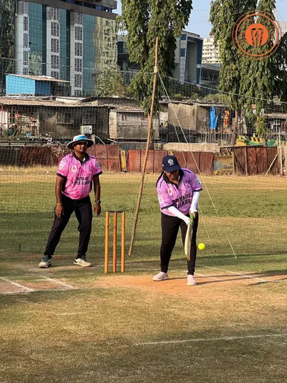A woman in a pink jersey gets ready to hit the ball in a competitive PPL match.