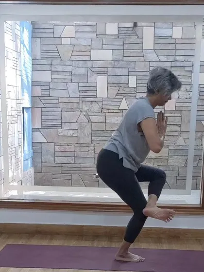 A student demonstrating a challenging balancing pose. Our classes help you build the strength and focus needed for such asanas.