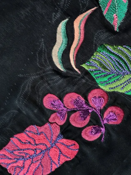 A collection of nature-inspired embroidery, with various leaf and flower patterns in bright, contrasting colors on a dark base.