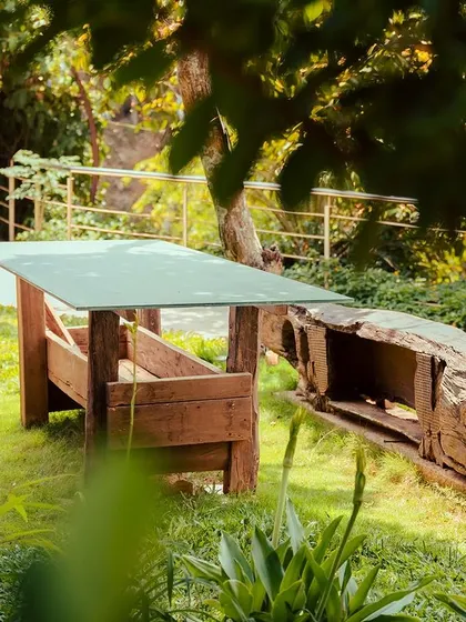 A rustic wooden table and benches set in a grassy clearing, a perfect spot for a picnic or quiet contemplation.