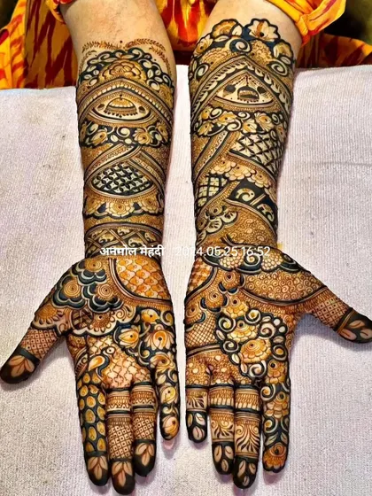 This is a very dense and intricate 'full-fill' mehendi design. The use of negative space is minimal, creating a rich tapestry of patterns that completely covers the hands and arms.
