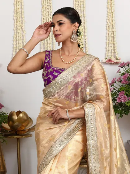 A close-up portrait of the model, showcasing the beautiful contrast between the ivory saree and the purple blouse.