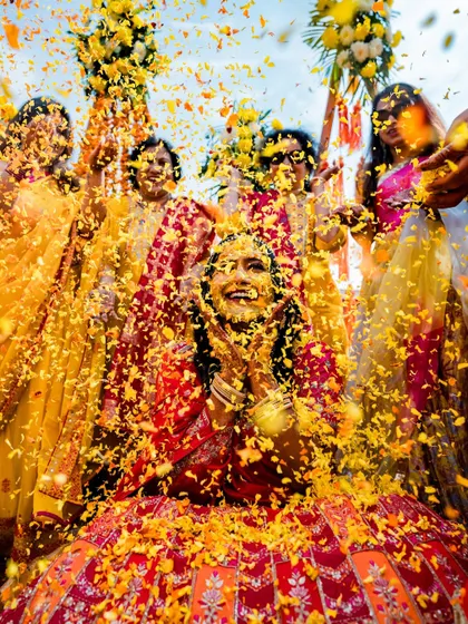 A vibrant shot of the bride being showered with marigold petals during her Haldi ceremony, a moment of pure joy.