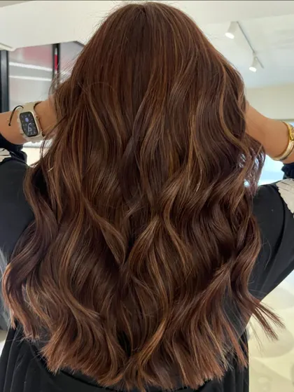 An auburn honey blend that brings so much warmth and life to the hair. The soft layered haircut complements the color, creating a healthy and vibrant look.