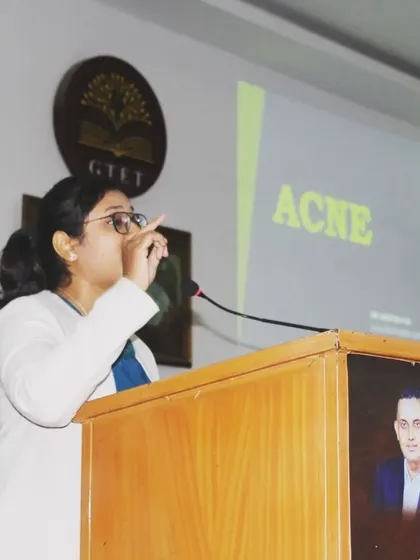 Making a point about acne treatment during a presentation. Clear communication is essential for patient education.