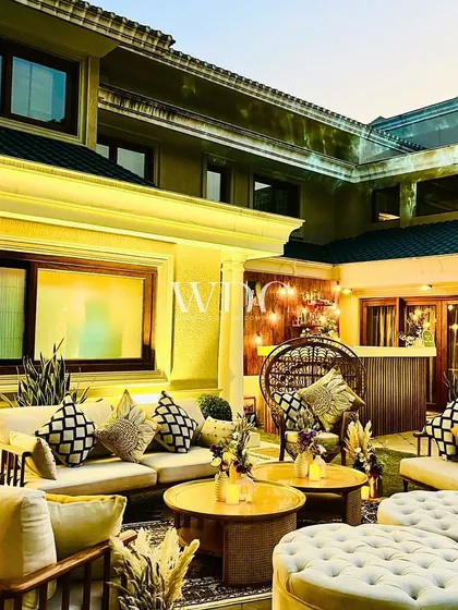 A wider view of the luxurious outdoor lounge, with comfortable sofas, patterned cushions, and warm lighting, perfect for a sophisticated birthday celebration.