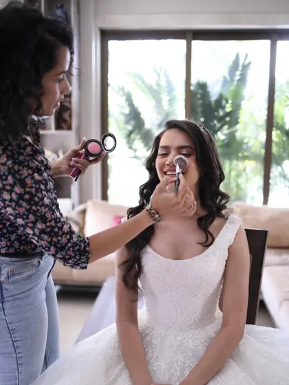 Getting Crystal ready was a joy. Here I am applying a soft blush to give her that perfect, natural flush that completes her ethereal bridal look.
