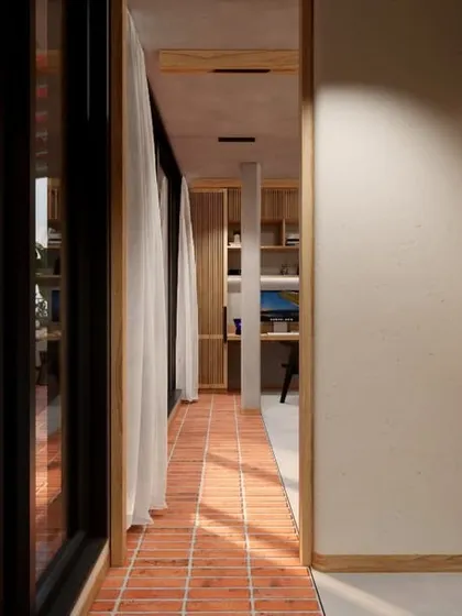 A view down the corridor of the HAUS 5 library, where the brick flooring from the terrace continues inside, further blurring the indoor-outdoor distinction.