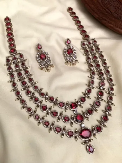 A three-layered necklace set with an antique silver finish. This long necklace is perfect for creating a layered, bohemian look and is available in green, blue, and red stones.