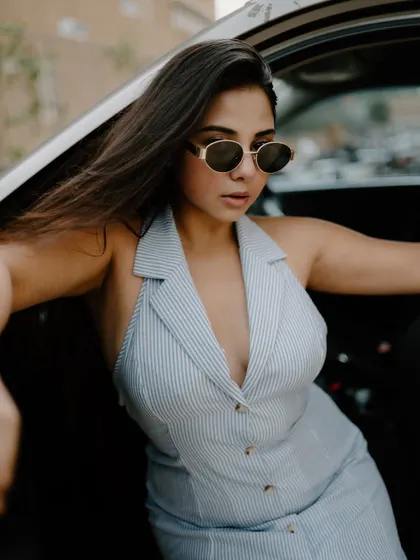 A creative portrait shot through a car window. The reflections and the model's pose create an artistic and moody fashion image.