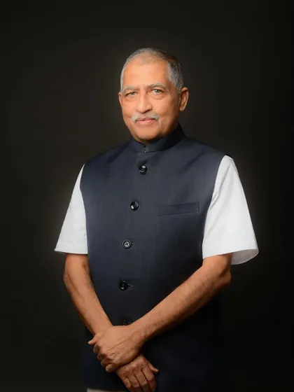 A distinguished portrait of a gentleman in a classic Nehru jacket. The dark background and simple lighting create a timeless and respectful image.