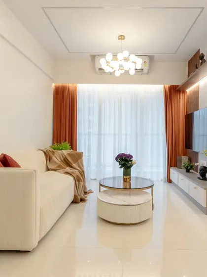 A wider view of the minimalist living room, showing how the simple color palette, clean lines, and ample light create a spacious and tranquil environment.